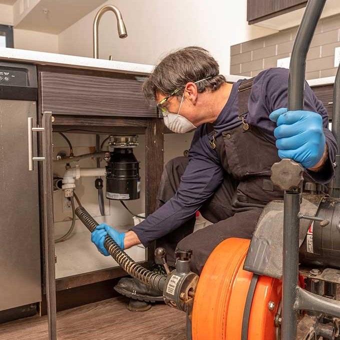 Technician Conductung Drain Cleaning Services